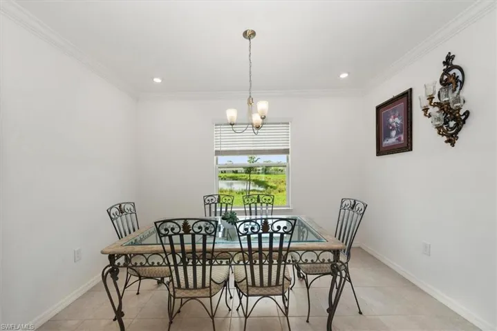 Dining space with light tile patterned floors, a chandelier, ornamental molding, and recessed lighting