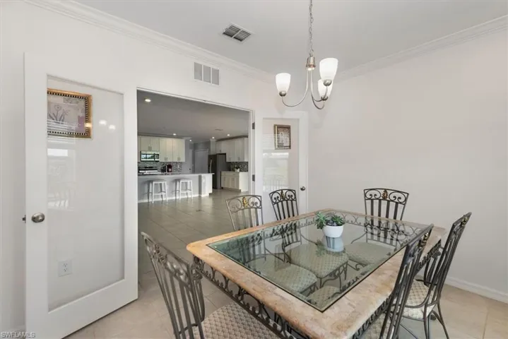 Dining space featuring crown molding, a chandelier, and light tile patterned floors