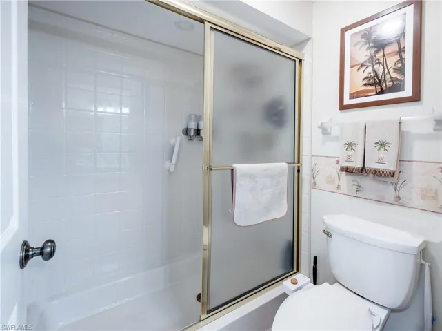 Bathroom with a shower with shower door and toilet