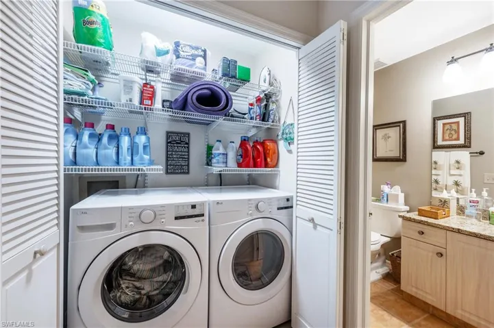 Laundry area featuring separate washer and dryer and light tile patterned flooring
