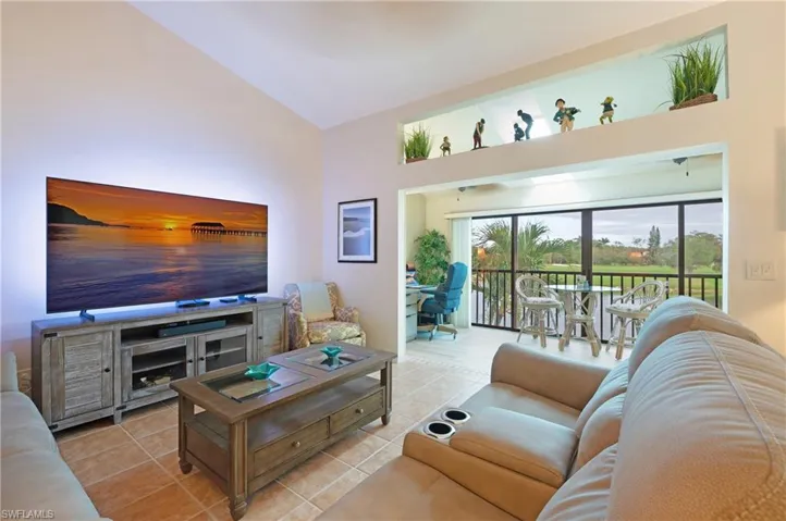 Tiled living room featuring high vaulted ceiling
