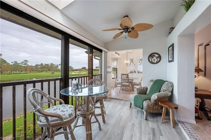Sunroom / solarium with lofted ceiling and ceiling fan with notable chandelier