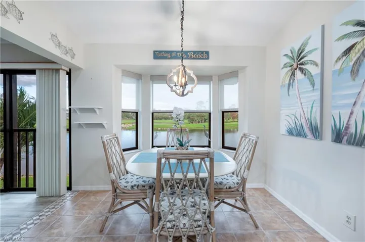 Dining room featuring a healthy amount of sunlight, a water view, and an inviting chandelier