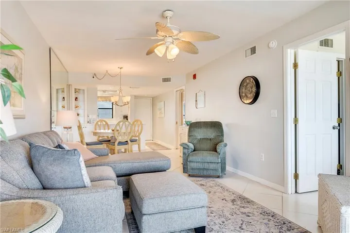 Living area with light tile patterned flooring and ceiling fan