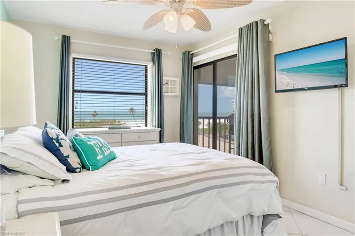 Bedroom with multiple windows, access to outside, a ceiling fan, and light tile patterned flooring