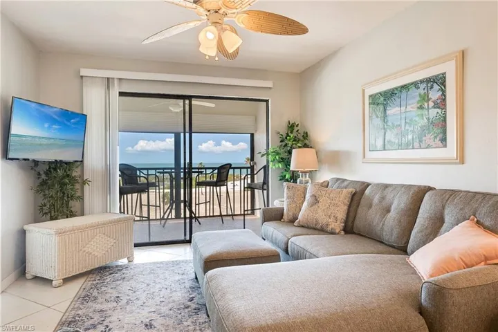 Living room with a ceiling fan and tile patterned flooring