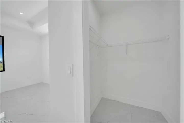 Walk in closet with light marble finish floors