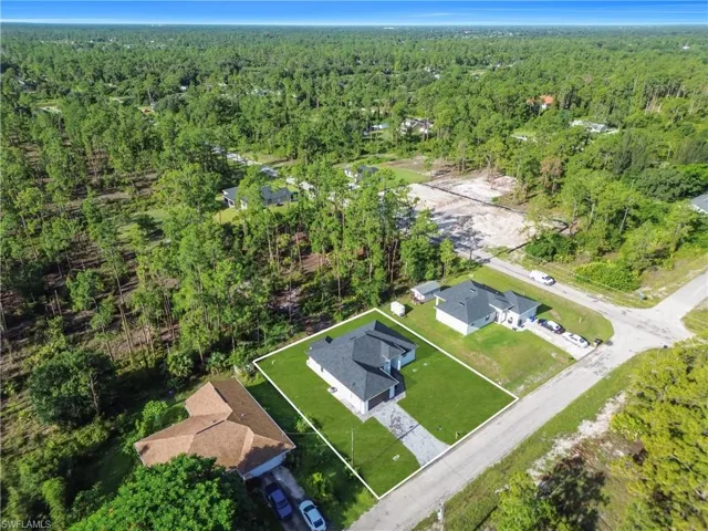 Aerial view of property and surrounding area featuring nearby suburban area and property parcel outlined