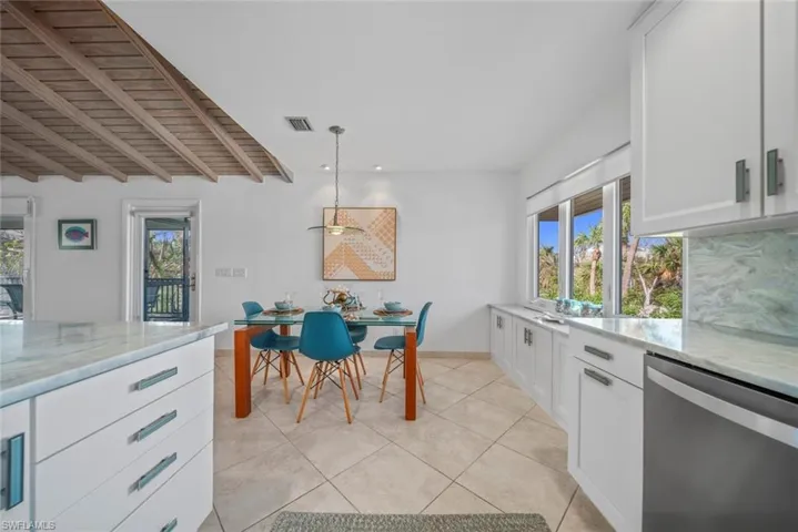 Kitchen featuring dishwasher, a wealth of natural light, white cabinets, and pendant lighting