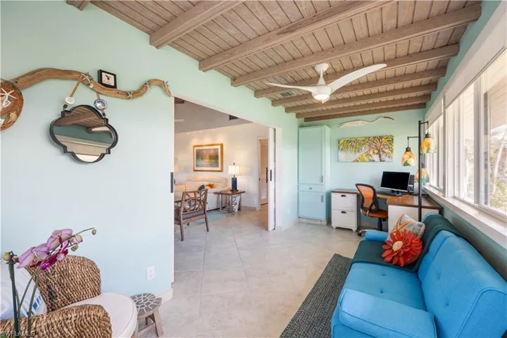 Tiled living room with ceiling fan, wooden ceiling, and beamed ceiling