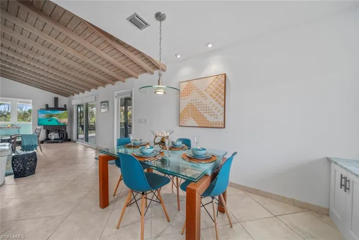 Dining space featuring wood ceiling, light tile patterned floors, and lofted ceiling with beams