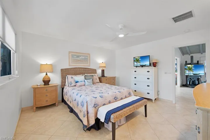 Tiled bedroom featuring ceiling fan