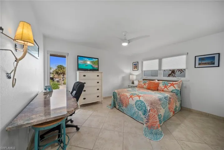 Tiled bedroom featuring ceiling fan