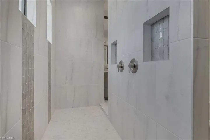 Owner's shower with two shampoo niches, upgraded tile, and rainfall shower head
