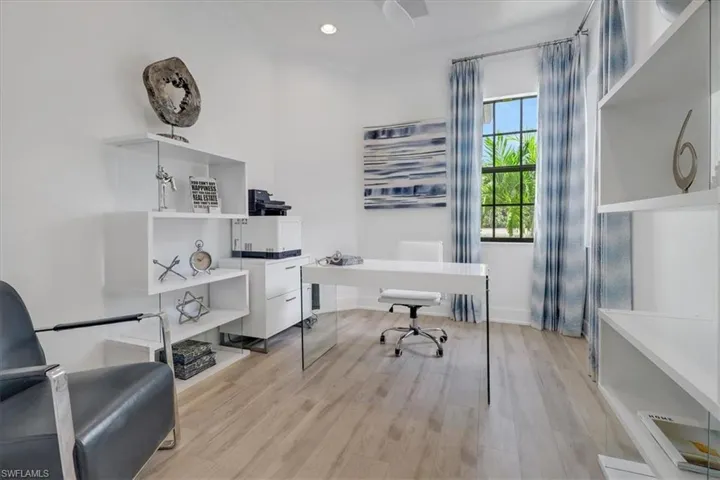 Home office with light wood-look LVP floors, recessed lighting, and glass french doors