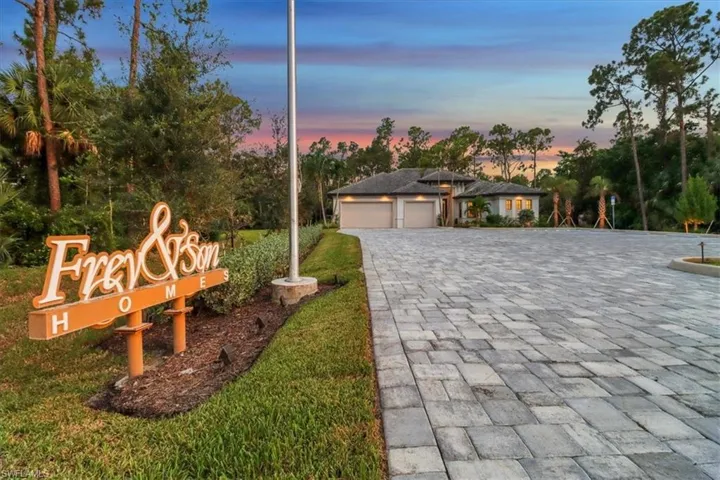 View of front of property with decorative driveway and an attached garage