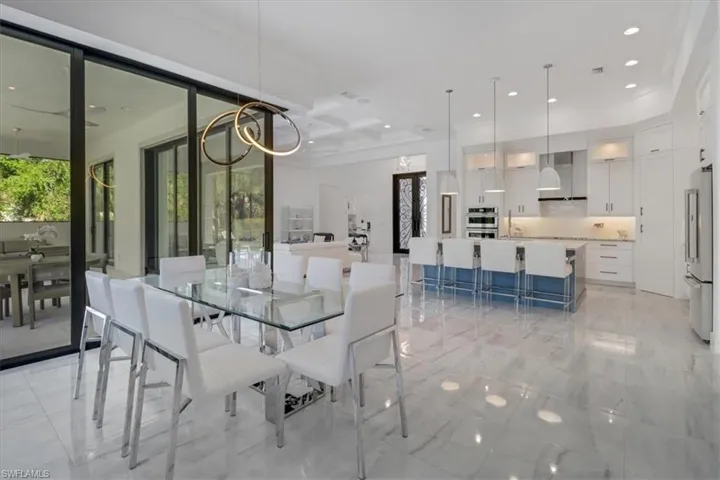 Dining room featuring recessed lighting, light porcelain tile floors and designer light fixture