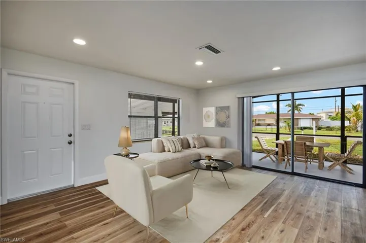 Living area with wood like finished floors and recessed lighting