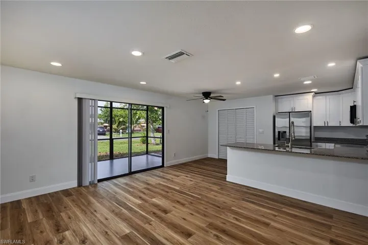 Living room with recessed lighting, a ceiling fan, and wood like finished floors