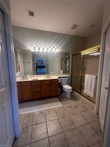 Bathroom featuring a sink, visible vents, and a stall shower