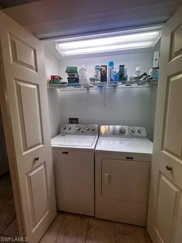 Laundry room with tile patterned floors, washer and dryer, and laundry area