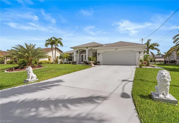 Mediterranean / spanish-style home featuring an attached garage, concrete driveway, a front lawn, and stucco siding