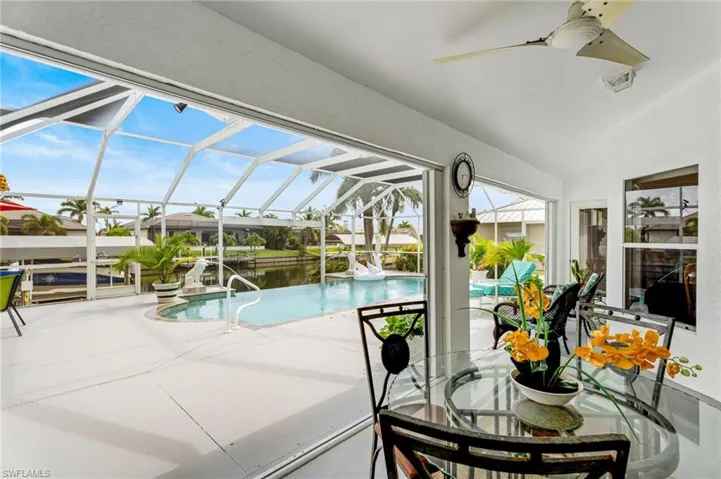 Sunroom / solarium featuring a ceiling fan, a swimming pool, and vaulted ceiling