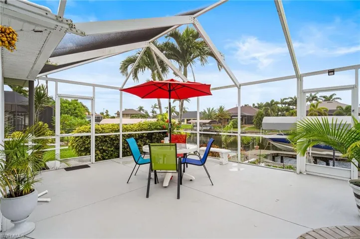 View of patio featuring a lanai, a water view, and outdoor dining space