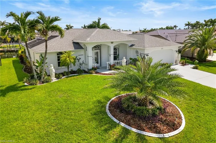 View of front of property featuring a shingled roof, stucco siding, an attached garage, a front lawn, and concrete driveway