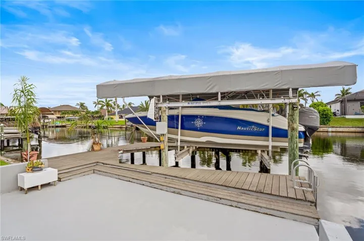 Dock area featuring boat lift and a water view