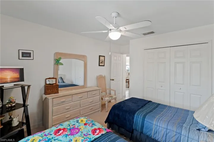 Bedroom featuring a closet, a ceiling fan, and light carpet