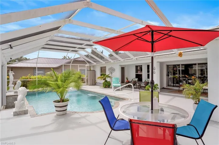 Outdoor pool with a patio area, glass enclosure, and outdoor dining area