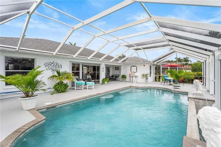 Outdoor pool with a patio area and glass enclosure