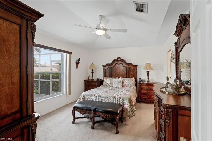 Bedroom with light colored carpet and a ceiling fan