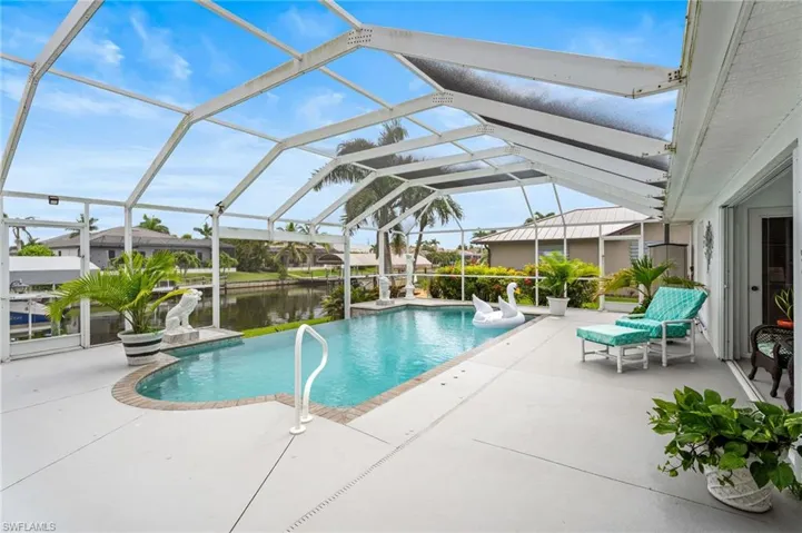 Outdoor pool featuring a patio, a water view, and a lanai