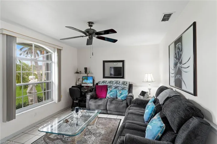 Living room with tile patterned flooring and a ceiling fan