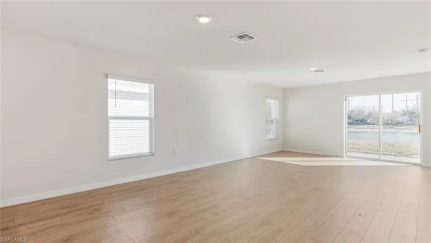 Model home. Unfurnished room with light wood-style flooring, a water view, and recessed lighting