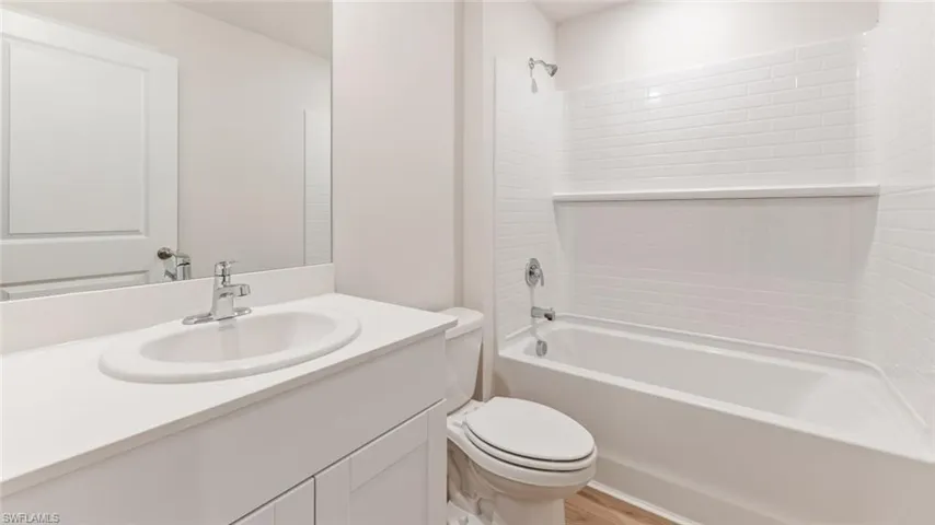 Model home. Full bathroom featuring shower / washtub combination, vanity, and light wood-style floors