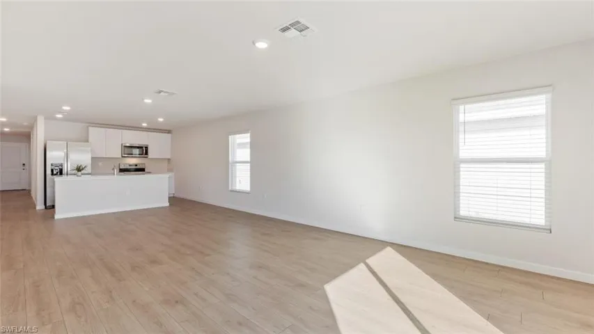 Model home. Unfurnished living room featuring recessed lighting and light wood-style flooring