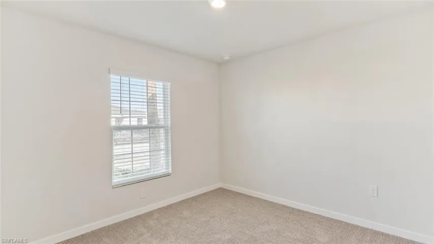 Model home. Carpeted spare room featuring baseboards