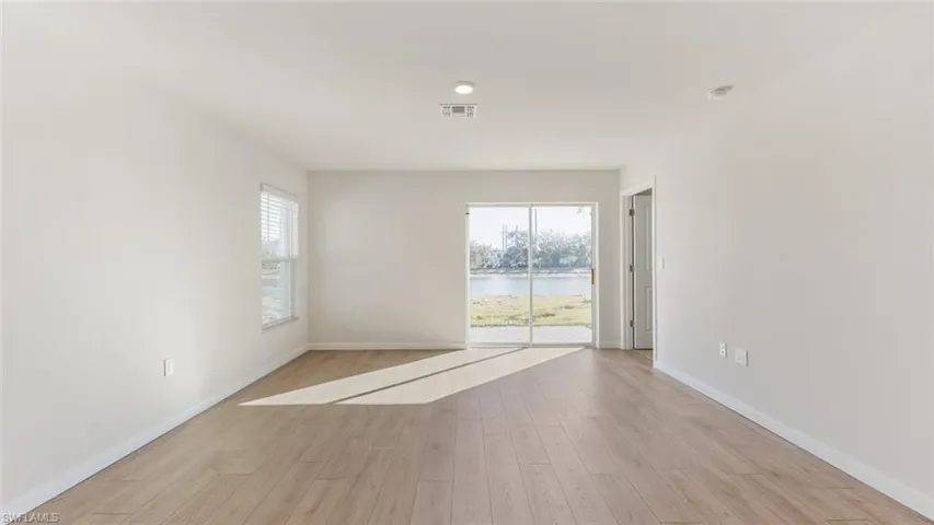 Model home. Unfurnished room featuring light wood-style flooring and a water view