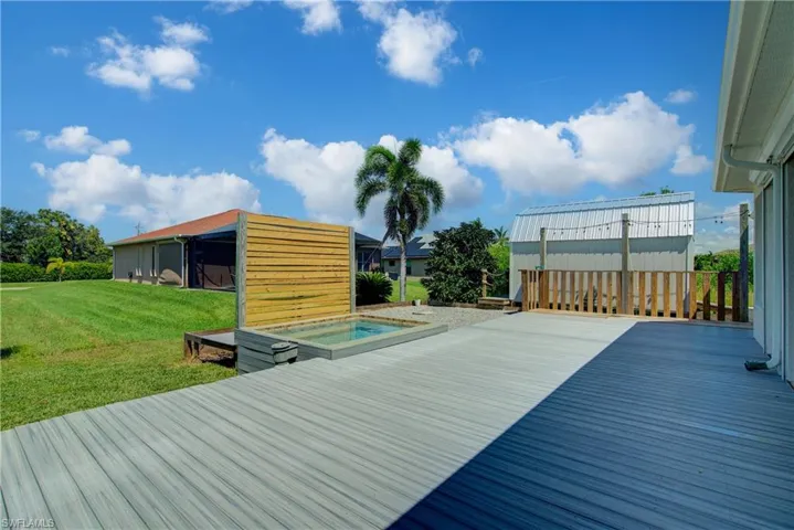 Deck with a hot tub and a yard