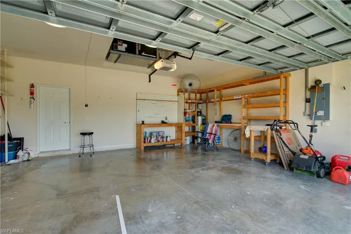 Garage featuring electric panel and a garage door opener