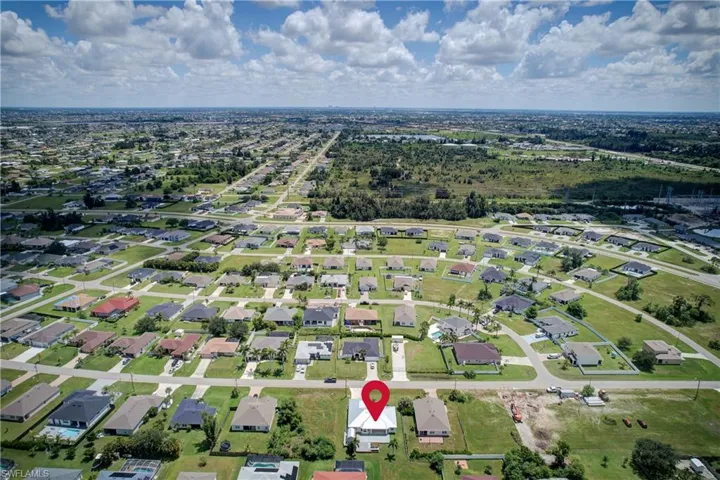 Aerial view of property's location with nearby suburban area