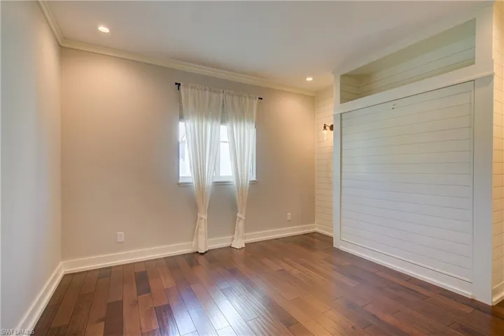 Unfurnished room featuring ornamental molding, dark wood-type flooring, and recessed lighting