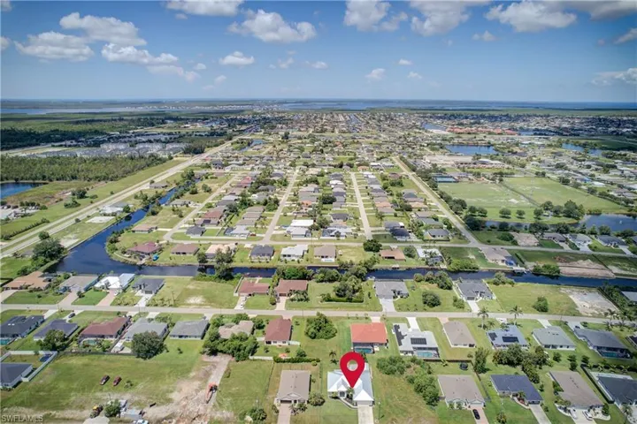 Aerial view of property's location with a nearby body of water and nearby suburban area