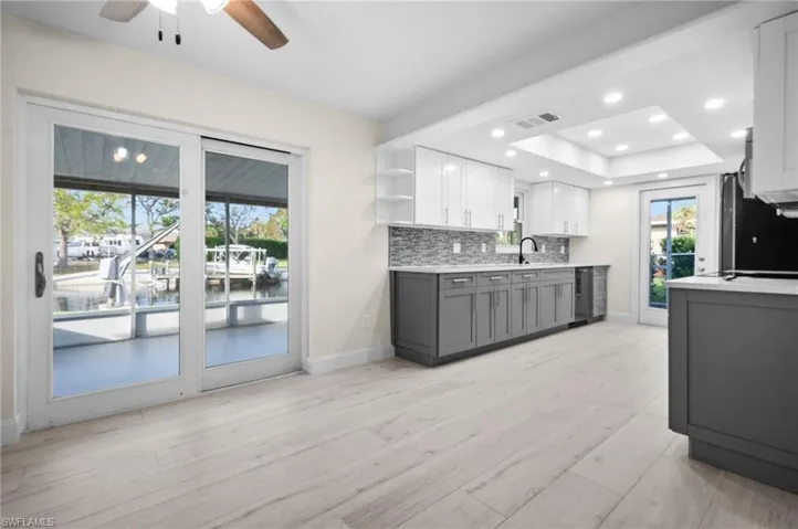 Kitchen with open shelves, tasteful backsplash, light countertops, visible vents, and gray cabinetry