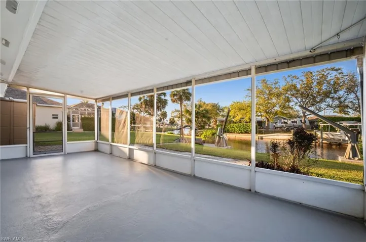 Unfurnished sunroom featuring a water view and a wealth of natural light