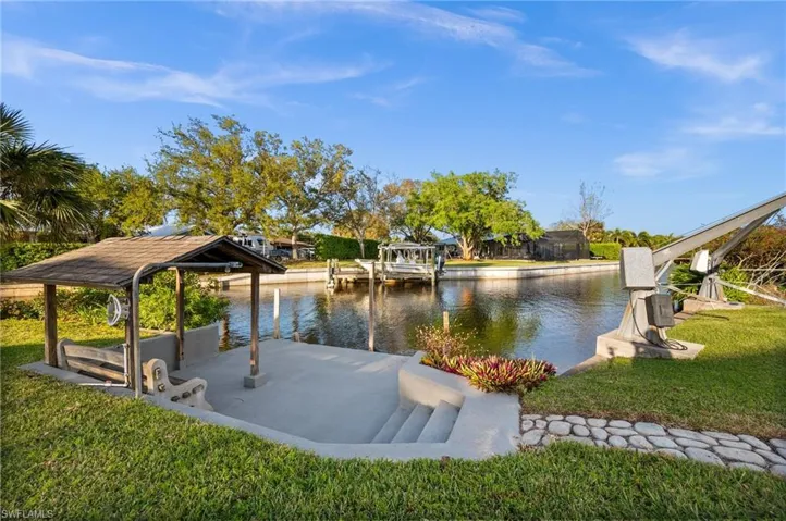 View of property's community with a water view, a yard, and a boat dock