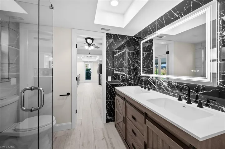 Bathroom with visible vents, a sink, tile walls, and toilet